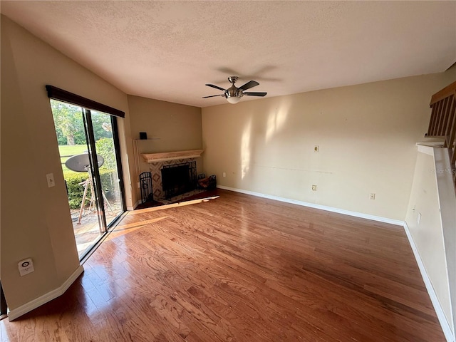 1886 Saint Andrews Pl Unit 1886, Longwood, FL 32779 - unfurnished living room featuring a ceiling fan, baseboards, a textured ceiling, a fireplace, and wood finished floors