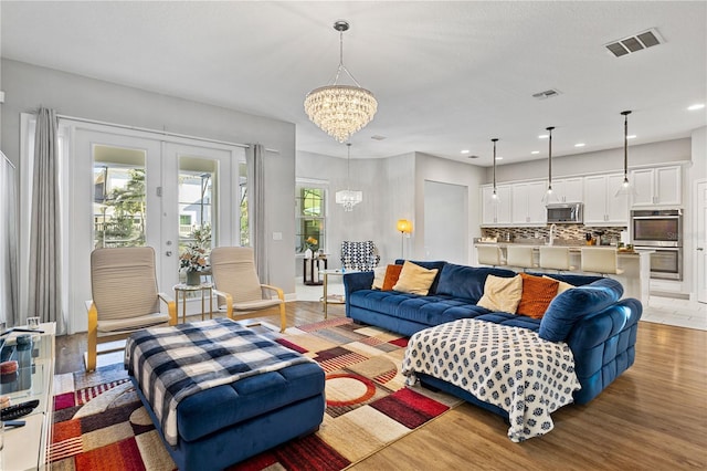 14645 Scott Key Dr, Winter Garden, FL 34787 - living room featuring light wood finished floors, visible vents, recessed lighting, and an inviting chandelier