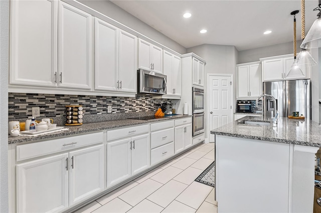 14645 Scott Key Dr, Winter Garden, FL 34787 - kitchen featuring a sink, stainless steel appliances, white cabinets, stone counters, and decorative backsplash