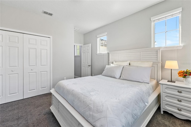 14645 Scott Key Dr, Winter Garden, FL 34787 - bedroom with a closet, visible vents, dark carpet, and a textured ceiling