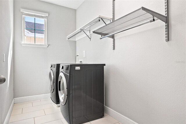 14645 Scott Key Dr, Winter Garden, FL 34787 - laundry room featuring light tile patterned flooring, laundry area, washing machine and dryer, and baseboards