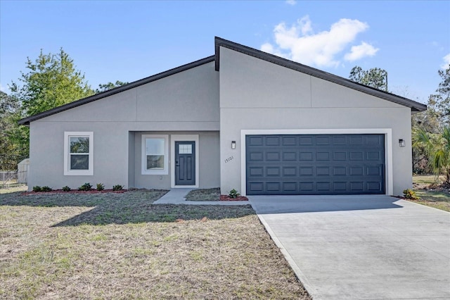view of front of property featuring stucco siding, driveway, a front yard, and an attached garage