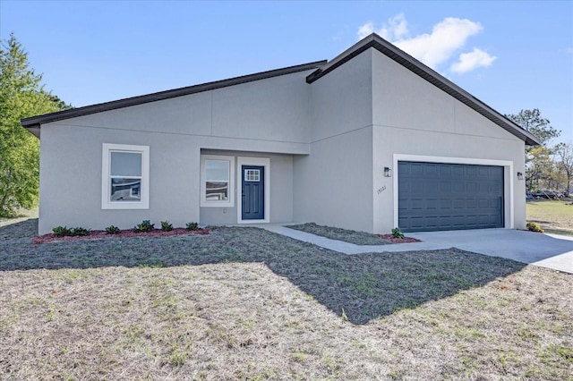 view of front facade featuring stucco siding, a front yard, concrete driveway, and an attached garage