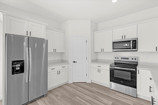 kitchen with light countertops, white cabinets, light wood-style floors, and appliances with stainless steel finishes