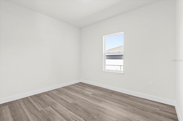 unfurnished room with wood finished floors and baseboards