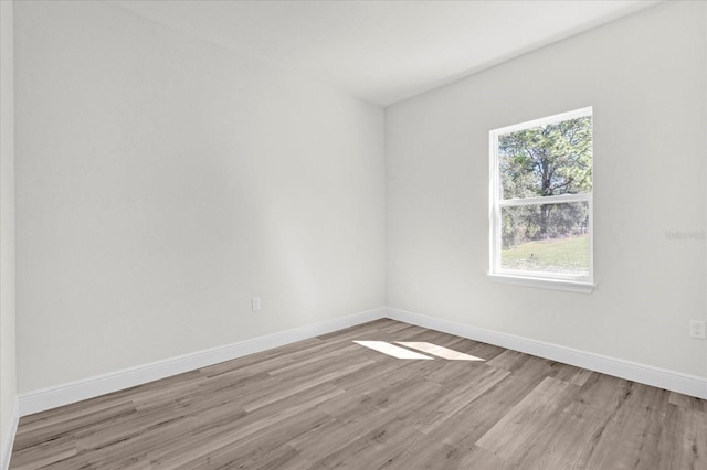empty room with light wood finished floors and baseboards