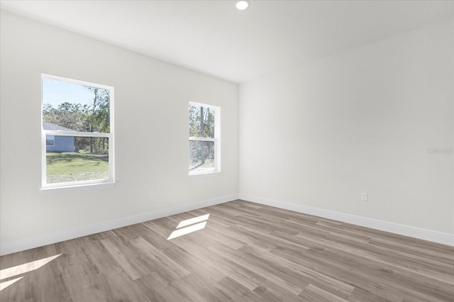 unfurnished room with recessed lighting, baseboards, and light wood-style floors