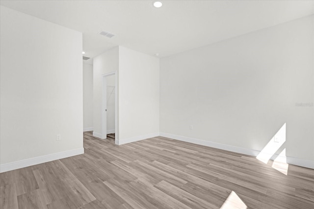 spare room featuring recessed lighting, visible vents, light wood-style flooring, and baseboards