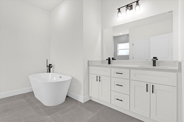 bathroom featuring double vanity, baseboards, tile patterned floors, and a freestanding bath