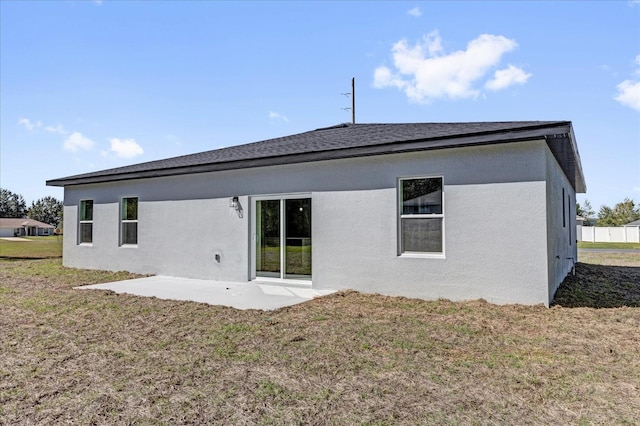 back of property with a lawn, a patio, and stucco siding