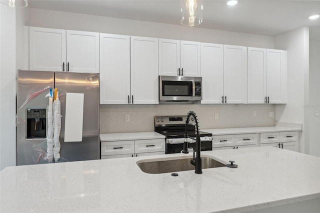 7550 N Gims Way, Citrus Springs, FL 34433 - kitchen featuring appliances with stainless steel finishes, white cabinetry, light stone countertops, recessed lighting, and hanging light fixtures