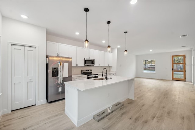 7550 N Gims Way, Citrus Springs, FL 34433 - kitchen with stainless steel appliances, white cabinets, a sink, light wood-style floors, and recessed lighting