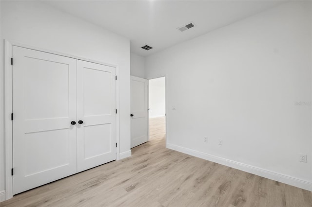 7550 N Gims Way, Citrus Springs, FL 34433 - unfurnished bedroom with light wood-style flooring, a closet, and baseboards