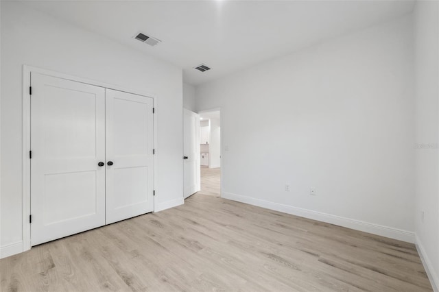 7550 N Gims Way, Citrus Springs, FL 34433 - unfurnished bedroom with light wood-type flooring, baseboards, and a closet