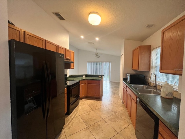 kitchen with visible vents, a peninsula, a sink, black appliances, and vaulted ceiling