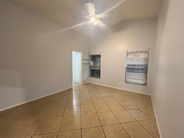 unfurnished room with light tile patterned floors, a ceiling fan, baseboards, and high vaulted ceiling