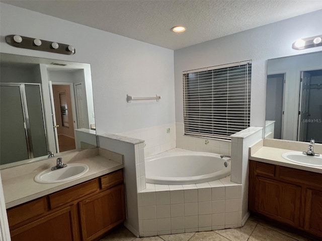 bathroom with a sink, a stall shower, tile patterned flooring, and a bath