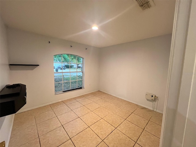 spare room featuring light tile patterned flooring, baseboards, and visible vents