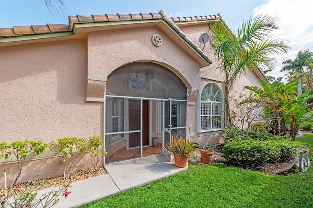 10589 Pelican Dr, Wellington, FL 33414 - property entrance featuring stucco siding, a yard, and a tile roof