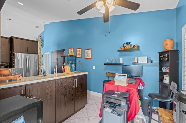 10589 Pelican Dr, Wellington, FL 33414 - kitchen with light tile patterned floors, a ceiling fan, lofted ceiling, freestanding refrigerator, and dark brown cabinets