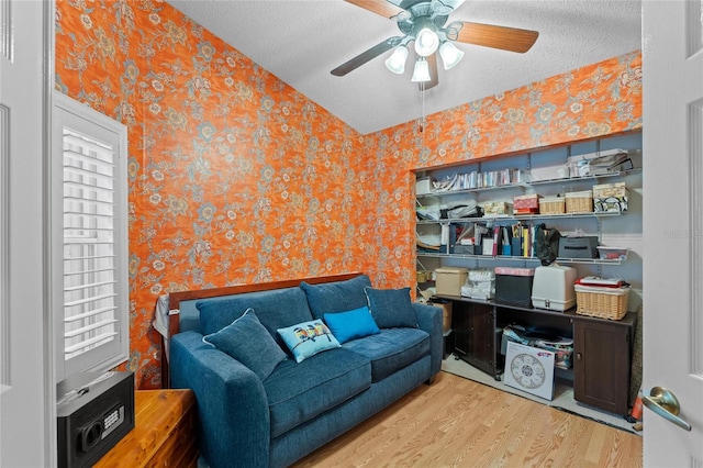 10589 Pelican Dr, Wellington, FL 33414 - sitting room with wallpapered walls, a textured ceiling, wood finished floors, and a ceiling fan