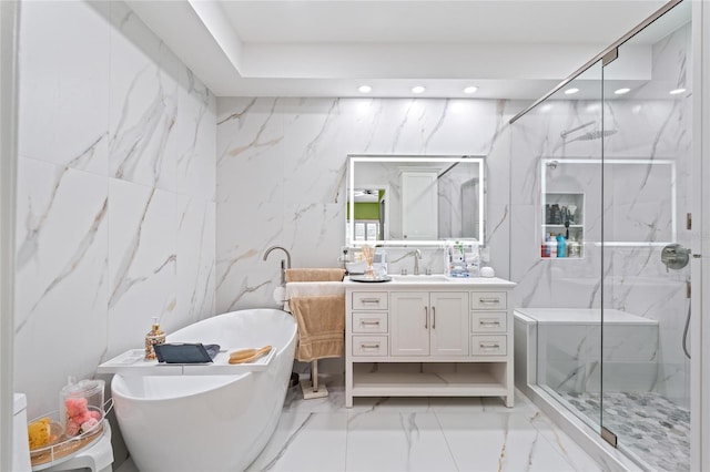 10589 Pelican Dr, Wellington, FL 33414 - full bathroom with marble finish floor, a marble finish shower, a soaking tub, stone wall, and vanity