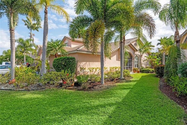 10589 Pelican Dr, Wellington, FL 33414 - view of side of property with stucco siding, a lawn, and a tile roof