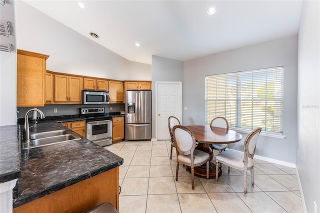 2361 Baker Ave, Orlando, FL 32833 - kitchen featuring dark countertops, light tile patterned floors, appliances with stainless steel finishes, brown cabinetry, and a sink