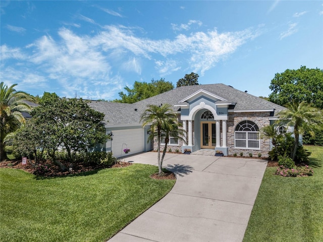 504 Sonata Ct, Winter Springs, FL 32708 - view of front of property featuring stone siding, an attached garage, a front yard, driveway, and french doors