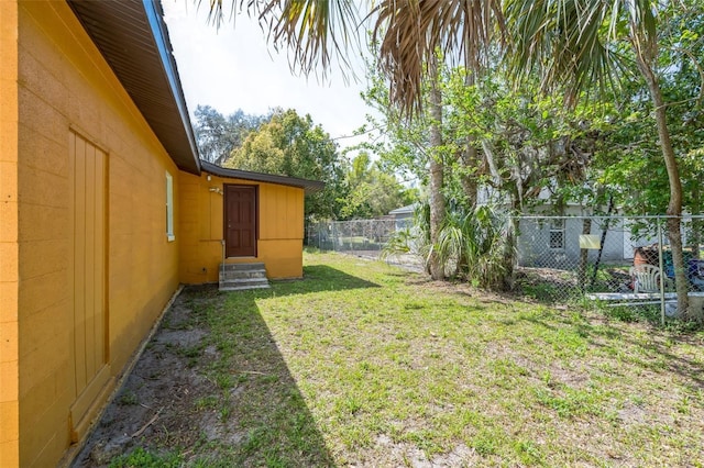 view of yard featuring entry steps and fence