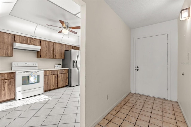 kitchen with a ceiling fan, stainless steel refrigerator with ice dispenser, under cabinet range hood, white electric stove, and light tile patterned flooring