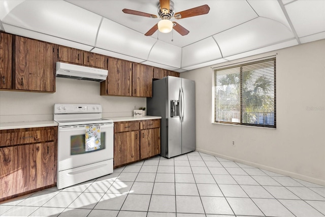 kitchen featuring light countertops, stainless steel refrigerator with ice dispenser, under cabinet range hood, and white range with electric stovetop