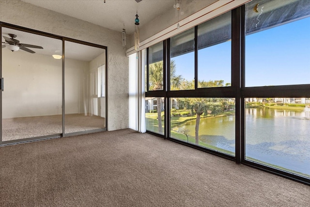 unfurnished sunroom with a water view and ceiling fan