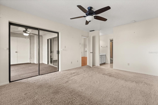 unfurnished bedroom featuring visible vents, a closet, carpet floors, connected bathroom, and ceiling fan