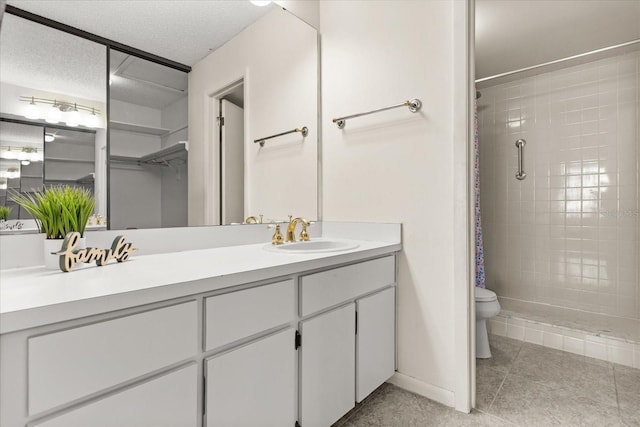 full bathroom featuring vanity, a stall shower, a textured ceiling, tile patterned floors, and toilet