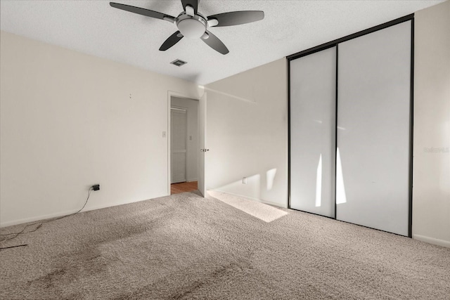 unfurnished bedroom featuring a closet, visible vents, a textured ceiling, and carpet floors
