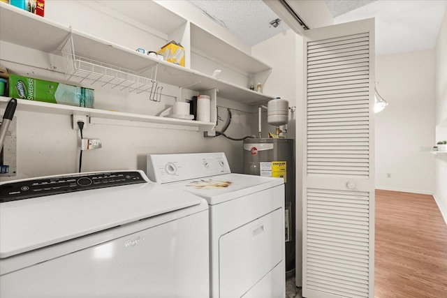 laundry room featuring light wood-style flooring, washer and clothes dryer, water heater, baseboards, and laundry area