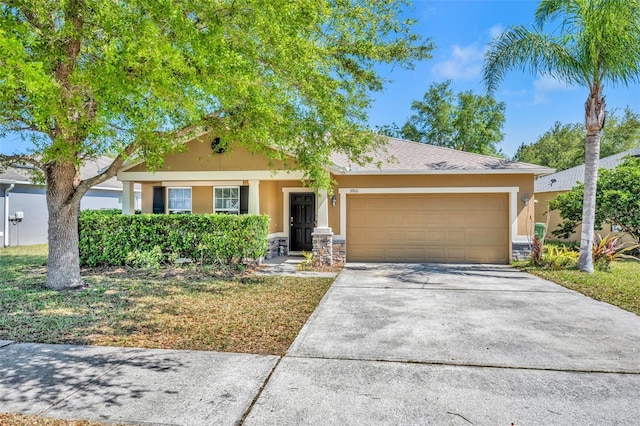 5910 Windsong Oak Dr, Leesburg, FL 34748 - view of front of property featuring stone siding, a garage, driveway, and stucco siding
