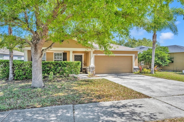 5910 Windsong Oak Dr, Leesburg, FL 34748 - view of front of house featuring concrete driveway, a garage, stone siding, and stucco siding