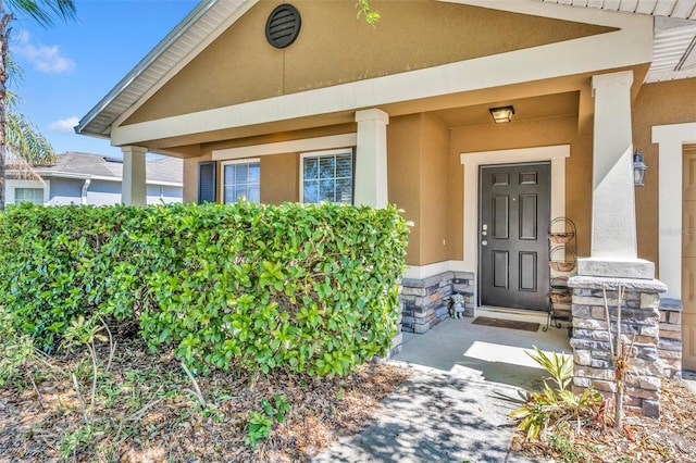 5910 Windsong Oak Dr, Leesburg, FL 34748 - view of exterior entry featuring stone siding and stucco siding