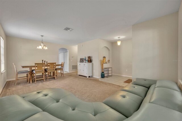 5910 Windsong Oak Dr, Leesburg, FL 34748 - living room featuring arched walkways, visible vents, light carpet, and a chandelier