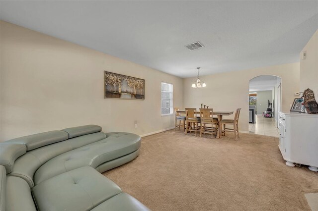 5910 Windsong Oak Dr, Leesburg, FL 34748 - living room featuring visible vents, light carpet, arched walkways, baseboards, and a chandelier