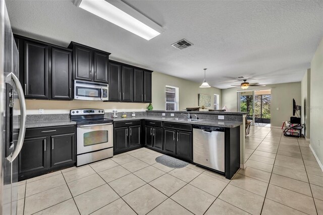 5910 Windsong Oak Dr, Leesburg, FL 34748 - kitchen featuring visible vents, a sink, stainless steel appliances, and dark cabinets