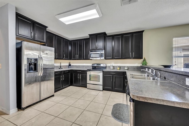 5910 Windsong Oak Dr, Leesburg, FL 34748 - kitchen with stainless steel appliances, dark cabinetry, and a sink