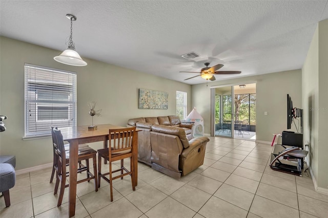 5910 Windsong Oak Dr, Leesburg, FL 34748 - dining space with light tile patterned floors, visible vents, a textured ceiling, and a ceiling fan