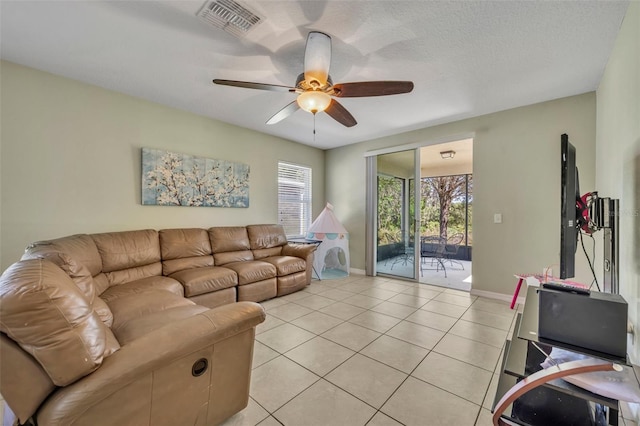 5910 Windsong Oak Dr, Leesburg, FL 34748 - living area with visible vents, a ceiling fan, a textured ceiling, light tile patterned flooring, and baseboards