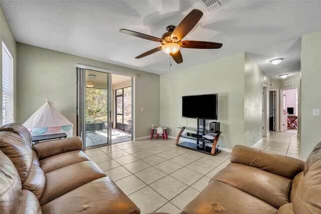 5910 Windsong Oak Dr, Leesburg, FL 34748 - living area with light tile patterned floors, visible vents, baseboards, and ceiling fan