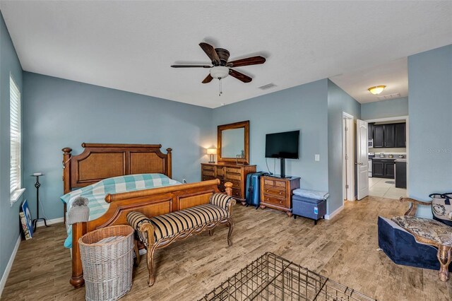 5910 Windsong Oak Dr, Leesburg, FL 34748 - bedroom with visible vents, baseboards, light wood-style floors, and a ceiling fan