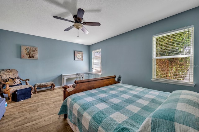 5910 Windsong Oak Dr, Leesburg, FL 34748 - bedroom with baseboards, a textured ceiling, a ceiling fan, and wood finished floors