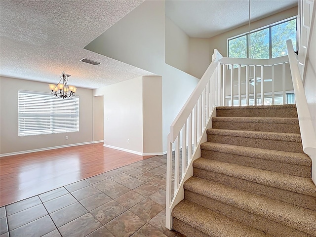 358 Morning Creek Cir, Apopka, FL 32712 - stairway featuring visible vents, baseboards, an inviting chandelier, tile patterned floors, and a textured ceiling